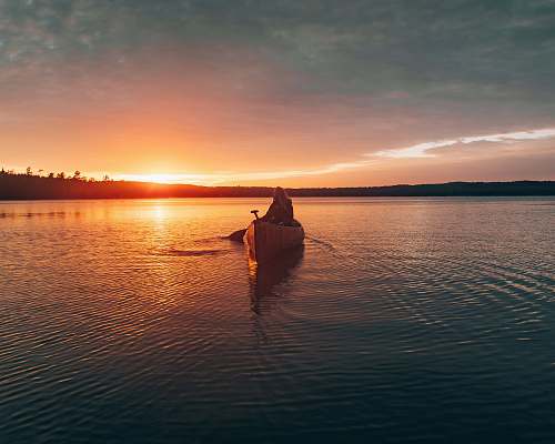 canoe person sailing canoe during sunset rowboat