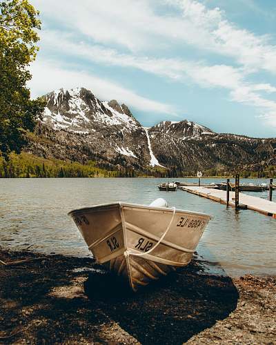 dinghy photo of white boat near body of water at daytime transportation