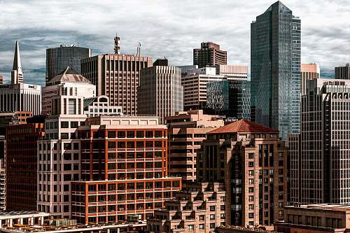 urban brown and gray concrete buildings taken under white clouds during daytime city