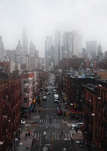 city cars parked between buildings under cloudy sky at daytime urban