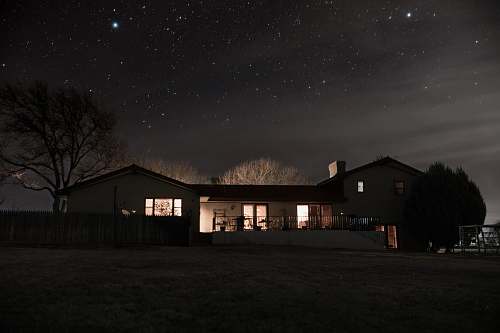 night landscape photography of a house under nightsky house