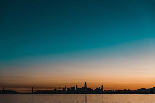 sky silhouette photography of buildings and body of water san francisco