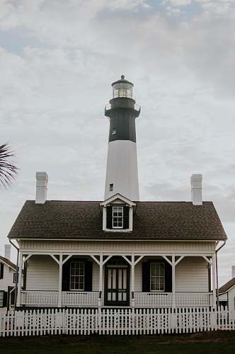 beacon white lighthouse under white sky cottage