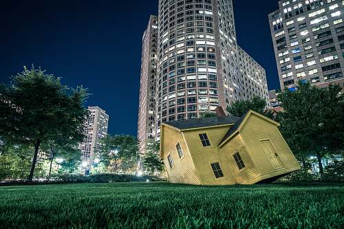 housing yellow house on green grass overlooking buildings at nighttime boston