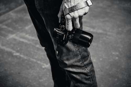 black-and-white grayscale photo of person holding DSLR camera ferry building