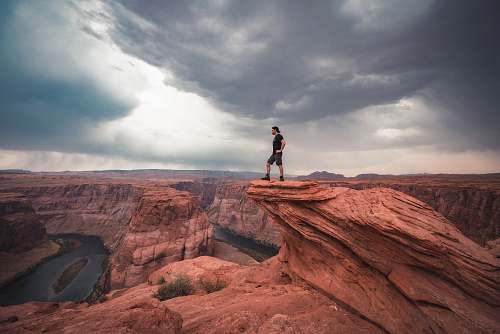 mountain man standing on top of horseshoe bend at Arizona nature