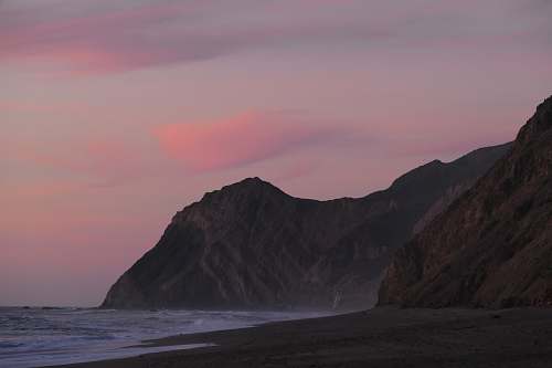 ocean mountain beside body of water coast
