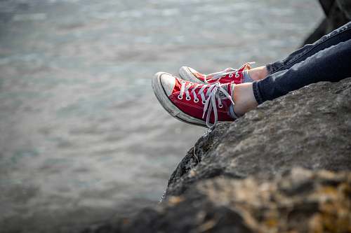 footwear person sitting on rock shoe