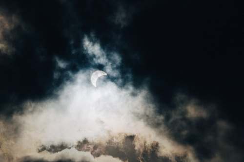 sky half moon hiding on white and black cloudy sky grey