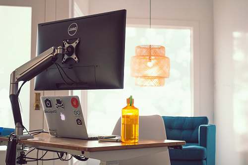 furniture black Dell computer monitor beside gray laptop on desk desk