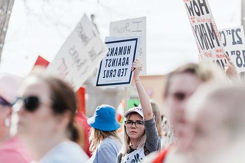 politics woman holding Humans Against Ted Cruz signage during daytime government