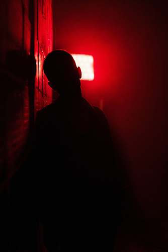 light man in black shirt standing near red light human