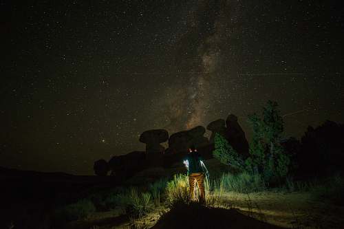 jar person standing near rock formation during night time plant