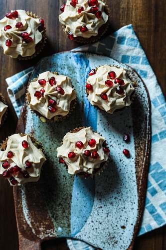 cake several muffins topped with cream and pomegranate seeds dessert