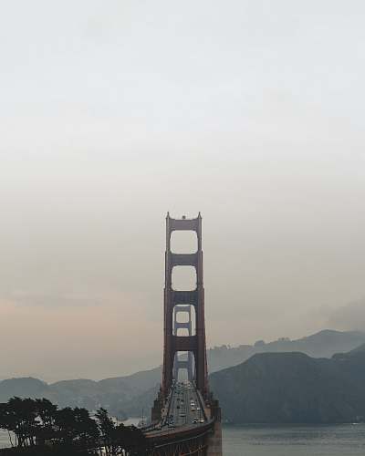 building brown gate bridge near hills and trees bridge