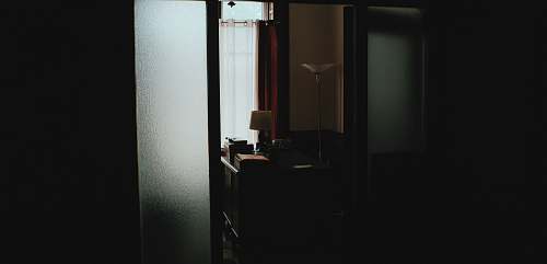 desk Dark hallway leading to office with desk and lamp office