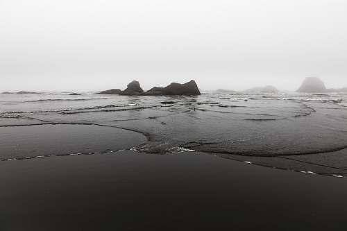 black-and-white island near body of water sand