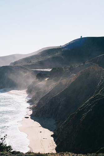 outdoors sea waves beside mountain during daytime nature