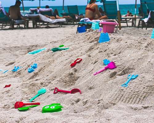 person assorted-color toys on sand sand