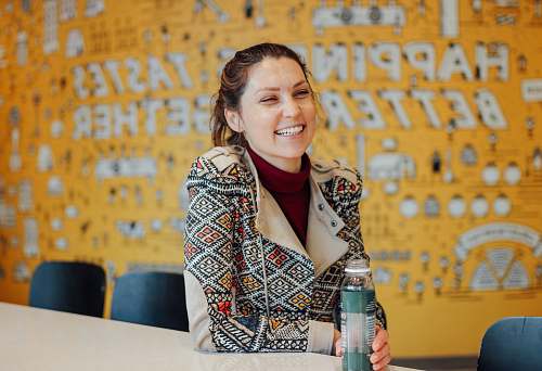 person close-up photography of smiling woman sitting beside table harvard