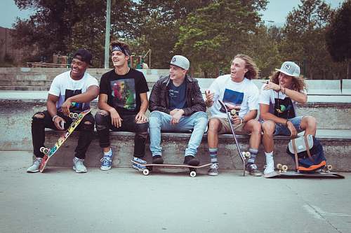people five group of men sitting together with their skateboards person