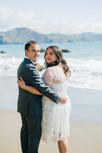 person groom and bride standing on seashore people