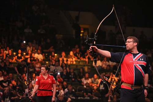 person man doing archery near woman holding bow bow