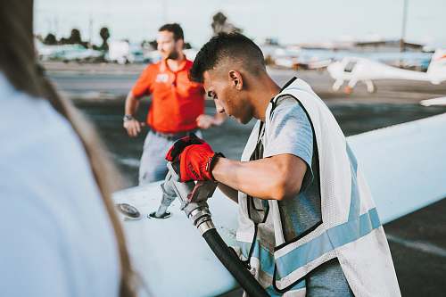 person man fueling plane near man airport