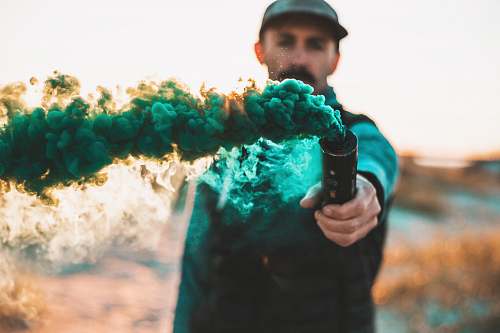 apparel man holding bottle with green smoke clothing
