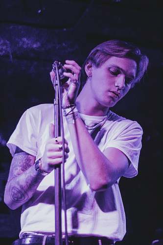 person man holding microphone on stand musical instrument