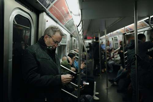 people man in gray coat standing near train door subway