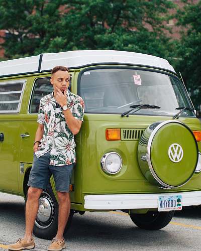 person man leaning on green Volkswagen vehicle apparel