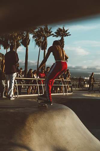 people man skateboarding surrounded people at daytime person