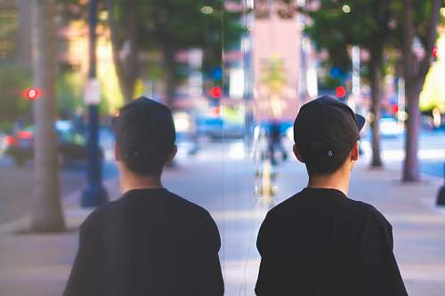 people man standing beside reflective wall person