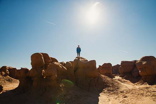 nature man standing on rock formation during daytime outdoors