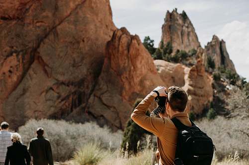 person man taking photo of rock formation people