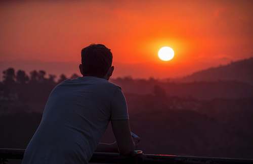 people man wearing blue shirt looking at sunset person