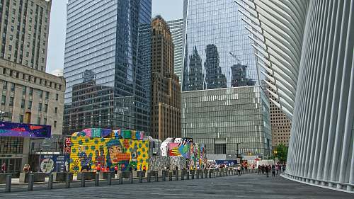 person murals at sidewalks beside buildings office building