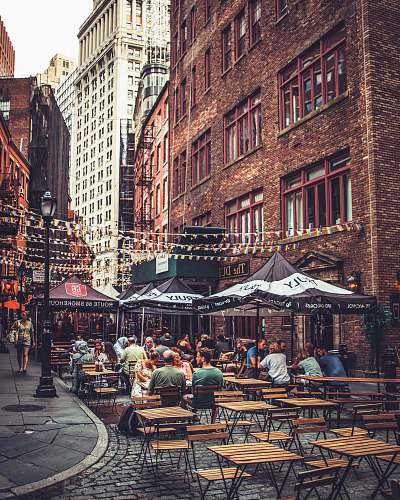 person people sitting near restaurant beside high-rise buildings restaurant
