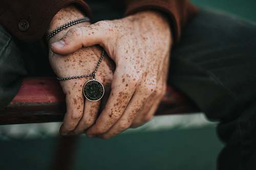 person person holding round gold-colored necklace people