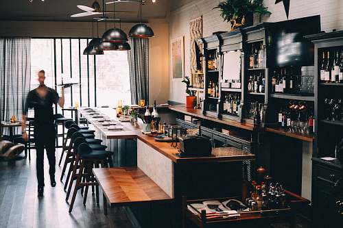 person person standing beside bar holding tray restaurant