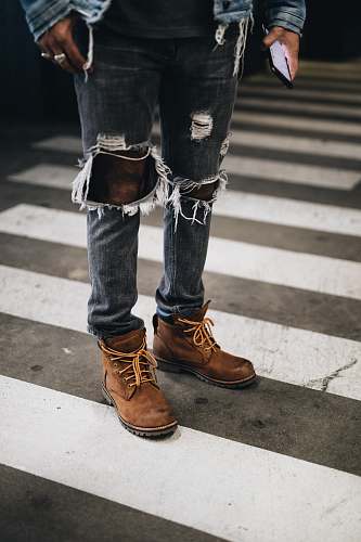 people person wearing distressed gray denim jeans standing on pedestrian line person