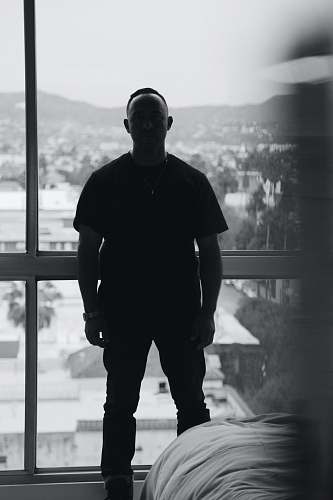 person silhouette of man wearing black crew-neck shirt black-and-white