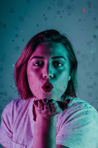 person woman blowing a flying kiss people