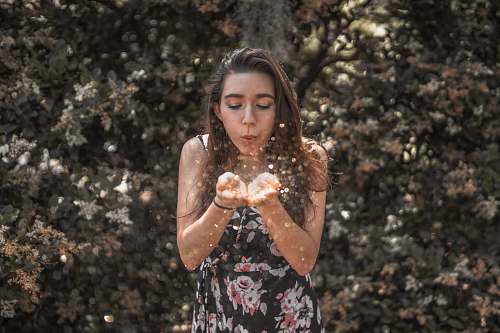 person woman blowing her hands people