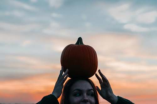 person woman carrying pumpkin on head people