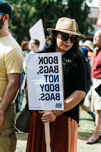 person woman holding book bags, not body bags. signboard people