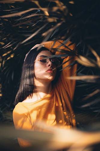 person woman holding her head white standing in the middle of plants people