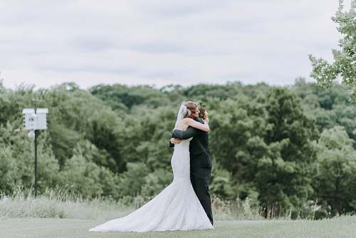 person woman hugging man standing on green grass field people