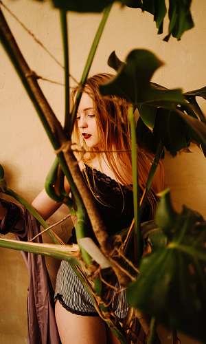person woman in black shirt holding green plant costume